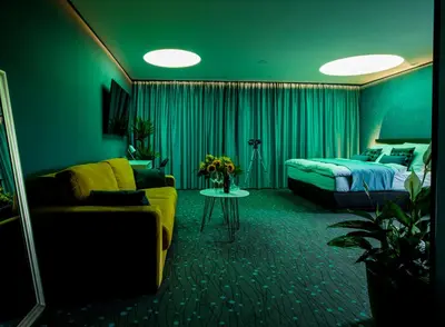 a bedroom with a bed and a couch and a bed and a table at Rooftop Planet Prague Hotel in Prague