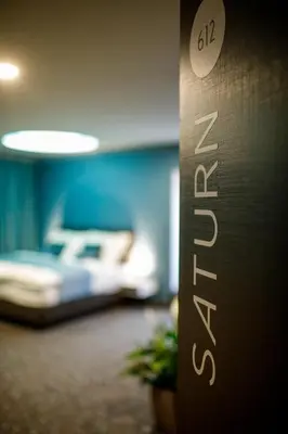 a sign in a hotel room with a bed at Rooftop Planet Prague Hotel in Prague