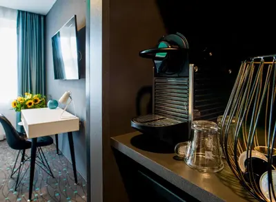 a hotel room with a sink and a room with a desk at Rooftop Planet Prague Hotel in Prague