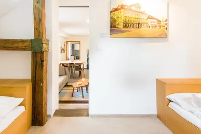 a bedroom with two beds and a dining room at Modern Apartment in a Picturesque 15th-Century Building in Prague