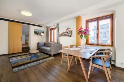 a living room with a table and a couch at Modern Apartment in a Picturesque 15th-Century Building in Prague