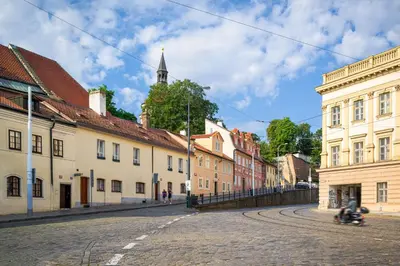 an empty street in a town with buildings at Modern Apartment in a Picturesque 15th-Century Building in Prague