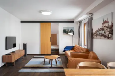 a living room with a couch and a tv at Modern Apartment in a Picturesque 15th-Century Building in Prague