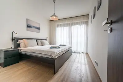 a bedroom with a bed and a large window at Mozart Central Apartments with garage in Prague