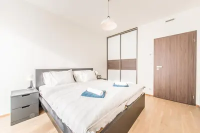 a bedroom with a large bed with white sheets at Mozart Central Apartments with garage in Prague
