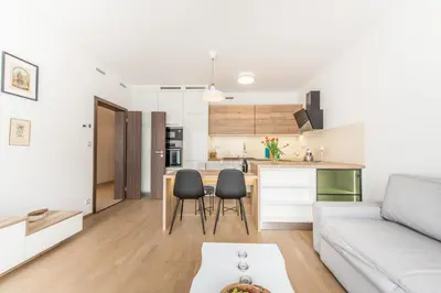 a living room and kitchen with a couch and a table at Mozart Central Apartments with garage in Prague
