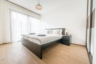 a bedroom with a bed and a large window at Mozart Central Apartments with garage in Prague