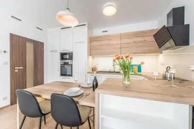 a kitchen with a wooden counter with chairs and a table at Mozart Central Apartments with garage in Prague