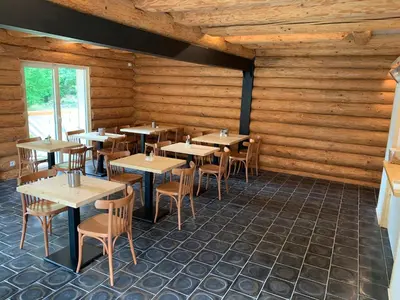 a restaurant with wooden walls and tables and chairs at penzion a kemp Harasov in Vysoká