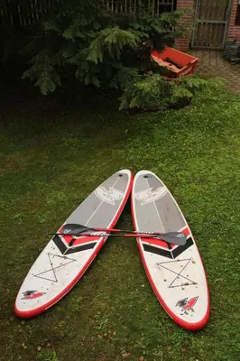 two surfboards sitting on the grass in the yard at penzion a kemp Harasov in Vysoká