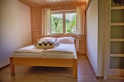 a bed in a room with a window at penzion a kemp Harasov in Vysoká
