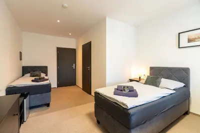 a bedroom with two beds and a flat screen tv at Restaurace Hotel Praha in Nižbor