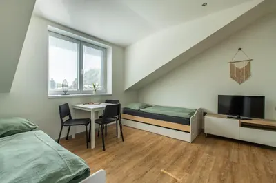 a bedroom with a bed and a table and a tv at Restaurace Hotel Praha in Nižbor