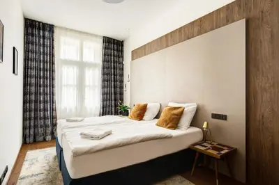 a bedroom with a large bed and a large window at Luxury Prague Riverside Apartment in Prague