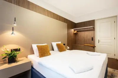 a hotel room with two beds and a door at Luxury Prague Riverside Apartment in Prague