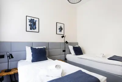 two beds with blue pillows in a room at Luxury Prague Riverside Apartment in Prague