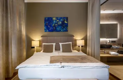 a bedroom with a large bed with a painting above it at Luxury Prague Riverside Apartment in Prague
