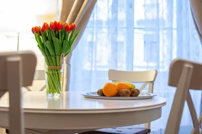 a table with a plate of oranges and a vase of flowers at Michalska Apartment in Prague