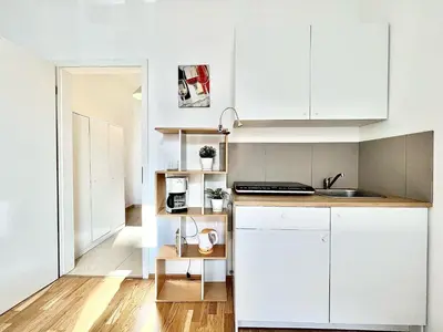 a kitchen with white cabinets and a sink at Maison Residence Prague in Prague
