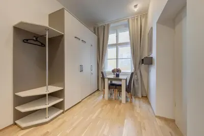 a room with a desk and a table with a window at Maison Residence Prague in Prague