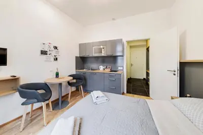 a bedroom with a bed and a table and chairs at Maison Residence Prague in Prague