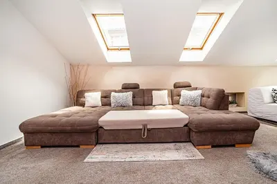 a living room with a brown couch with skylights at LaNoblessa in Prague