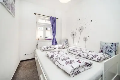 two beds in a white room with a window at LaNoblessa in Prague