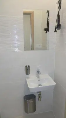 a white bathroom with a sink and a mirror at HU in Prague
