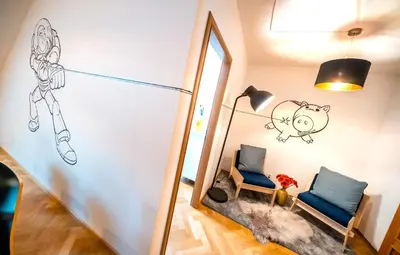 a hallway with a mirror and a chair and a lamp at Klimentska Cartoon apartments in Prague