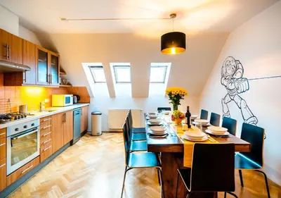 a kitchen and dining room with a table and chairs at Klimentska Cartoon apartments in Prague