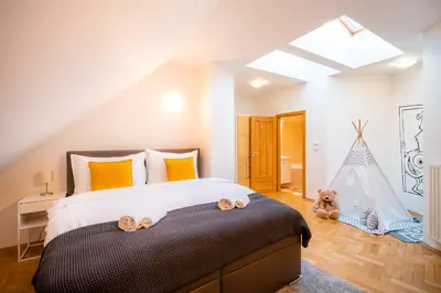 a bedroom with a bed with a teddy bear on the floor at Klimentska Cartoon apartments in Prague