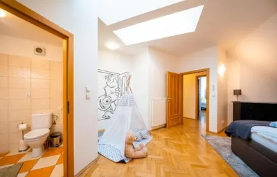 a bedroom with a bed and a bathroom with a toilet at Klimentska Cartoon apartments in Prague