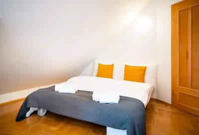 a bedroom with a bed with orange and white pillows at Klimentska Cartoon apartments in Prague