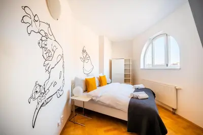 a bedroom with a bed and a window at Klimentska Cartoon apartments in Prague