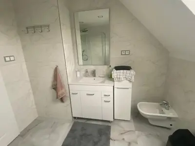 a white bathroom with a sink and a toilet at Homestay U Hanky in Zdiby