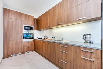 a kitchen with wooden cabinets and a sink at REZIDENCE ŠVEHLOVA in Prague