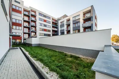 an apartment building with a white wall and a bench at REZIDENCE ŠVEHLOVA in Prague