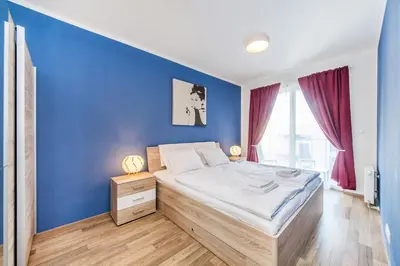 a bedroom with a blue wall and a bed at REZIDENCE ŠVEHLOVA in Prague