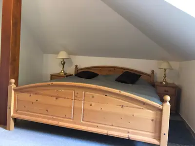 a bedroom with a wooden bed with two lamps at Malá Svatá Hora - penzion & restaurace in Mníšek pod Brdy