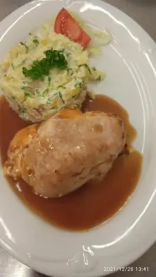 a plate of food with meat and potatoes and gravy at Malá Svatá Hora - penzion & restaurace in Mníšek pod Brdy