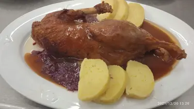 a plate of food with a piece of chicken and potatoes at Malá Svatá Hora - penzion & restaurace in Mníšek pod Brdy
