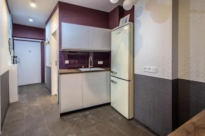 a kitchen with white cabinets and a refrigerator at Colorful Day in Prague Design Apartments in Prague