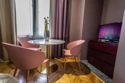 a room with a table and chairs and a tv at Colorful Day in Prague Design Apartments in Prague