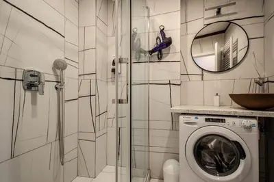 a bathroom with a washing machine and a mirror at Colorful Day in Prague Design Apartments in Prague