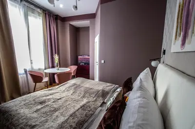 a bedroom with a bed and a table and a window at Colorful Day in Prague Design Apartments in Prague