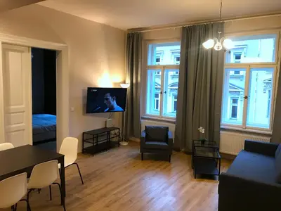 a living room with a couch and a tv in it at Valentine's National Museum Apartments in Prague