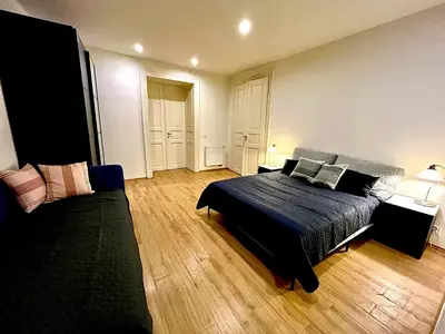 a bedroom with a black bed and a couch at Valentine's National Museum Apartments in Prague