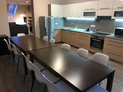 a kitchen with tables and white chairs in a room at Valentine's National Museum Apartments in Prague