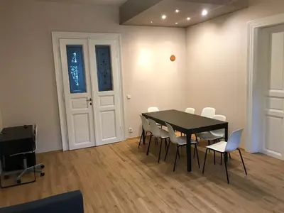 a dining room with a black table and white chairs at Valentine's National Museum Apartments in Prague