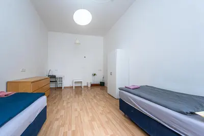 a bedroom with two beds and a wooden floor at Dittrichova Apartment in Prague